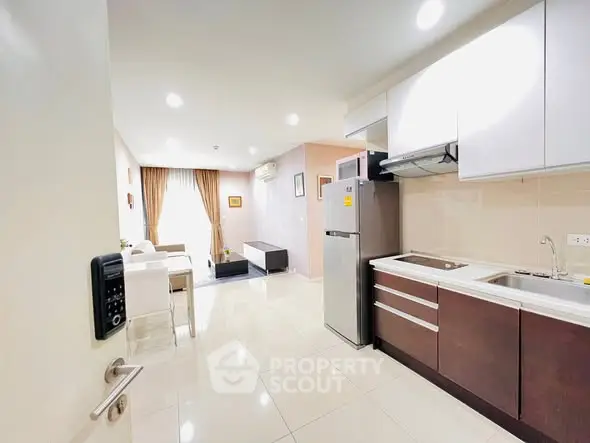 Modern open-plan kitchen and living room with sleek appliances and stylish decor.