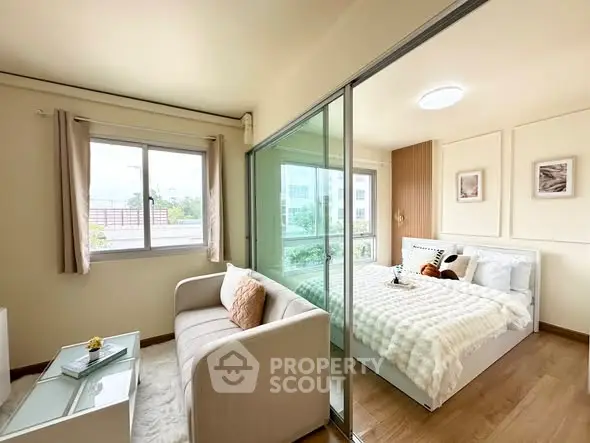 Modern bedroom with sliding glass doors and cozy living area in a stylish apartment.