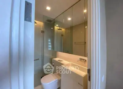 Modern bathroom with glass shower and sleek fixtures in a contemporary apartment.