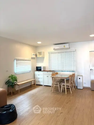 Spacious living room with modern furniture and wooden flooring, perfect for family gatherings.