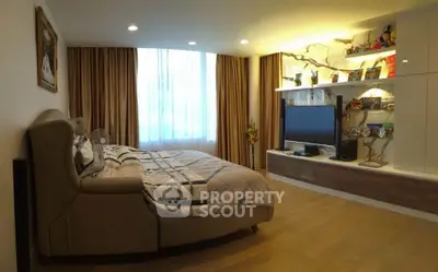Spacious bedroom with modern decor and entertainment center