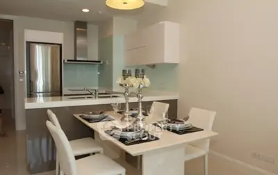 Modern kitchen with dining area featuring sleek design and elegant table setting.