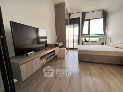 Modern bedroom with large TV and balcony view in stylish apartment