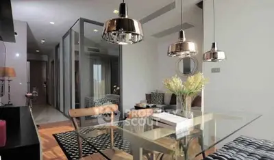 Modern living room with glass dining table and stylish pendant lights in a chic apartment.