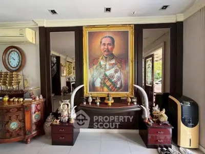 Elegant living room with royal portrait and traditional decor, showcasing cultural charm and sophistication.