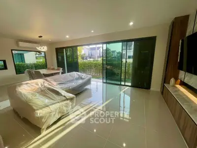 Spacious living room with large windows and modern decor in a luxury home.
