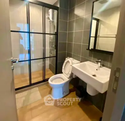 Modern bathroom with sleek design, featuring a glass shower enclosure and contemporary fixtures.