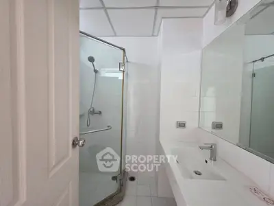 Modern bathroom with glass shower and sleek white sink