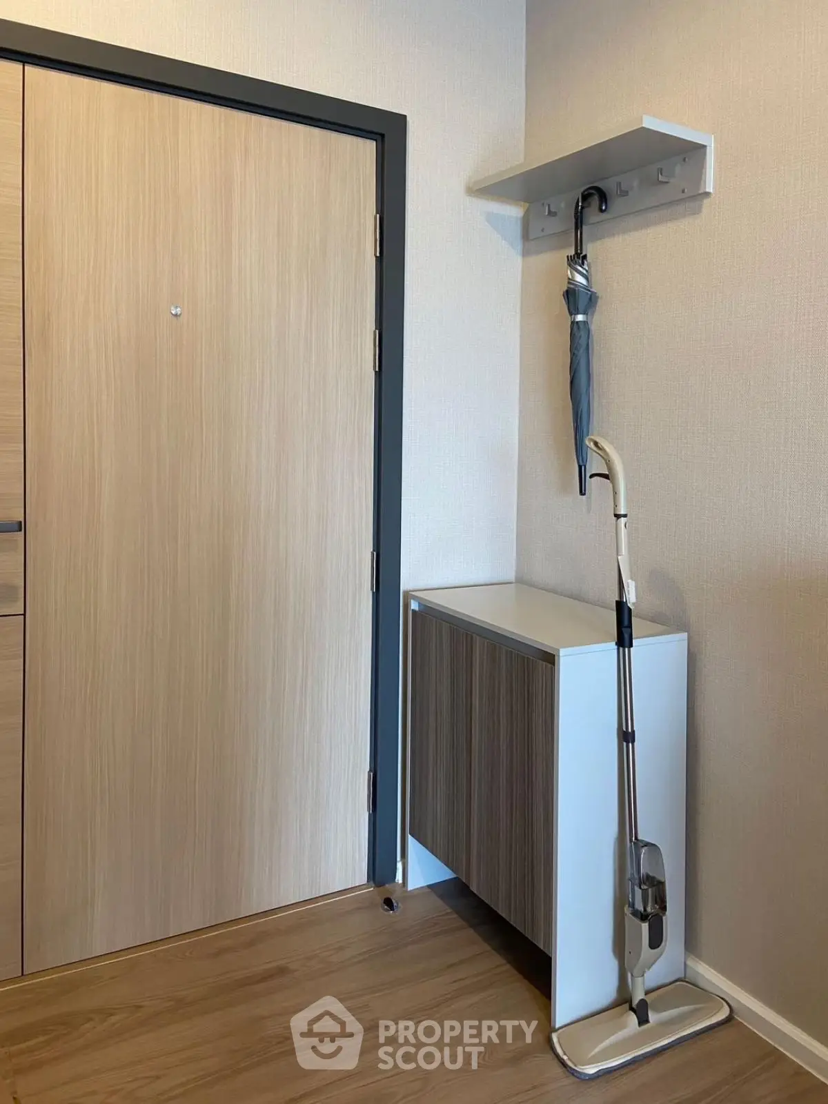 Modern entryway with wooden door, sleek cabinet, and umbrella storage