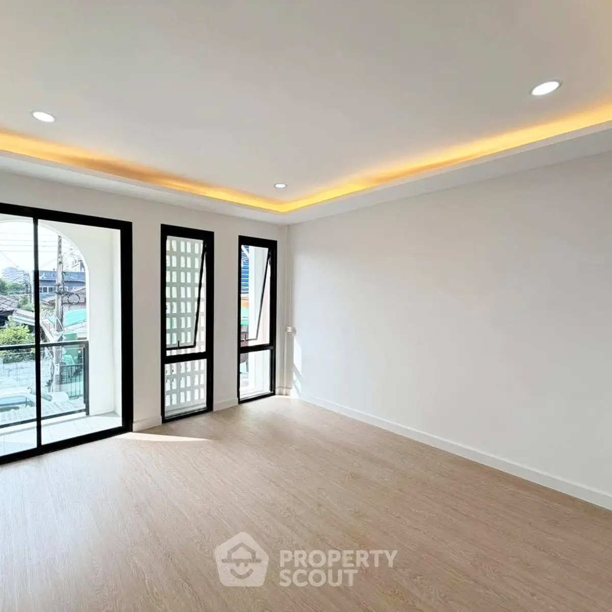 Spacious modern living room with large windows and elegant lighting