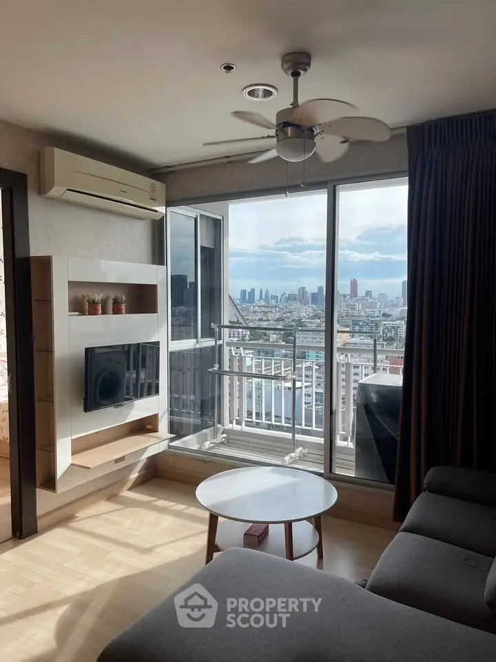 Modern living room with city view, featuring sleek furniture and large windows for natural light.
