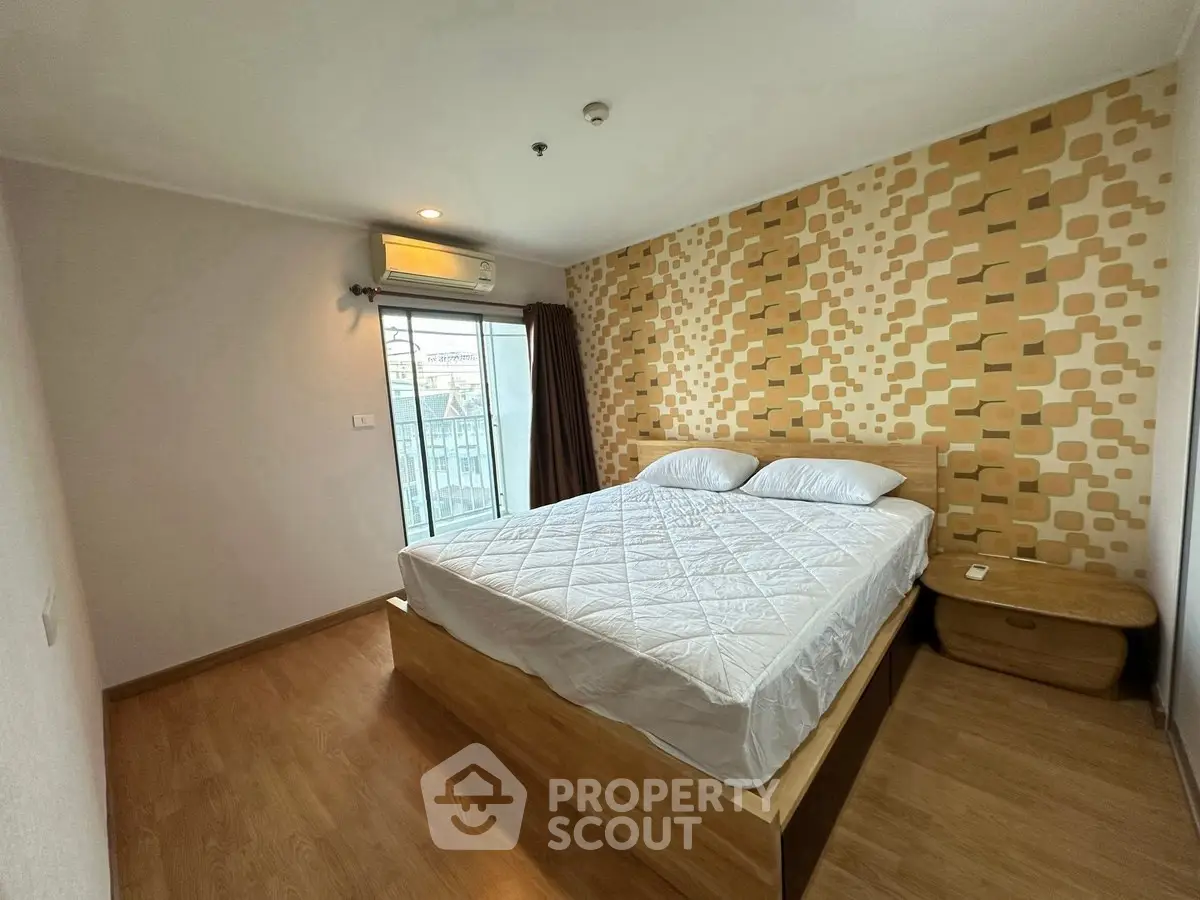 Spacious bedroom with modern decor and large window offering natural light.