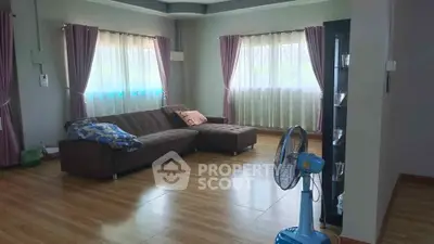Spacious living room with modern sofa and large windows for natural light.