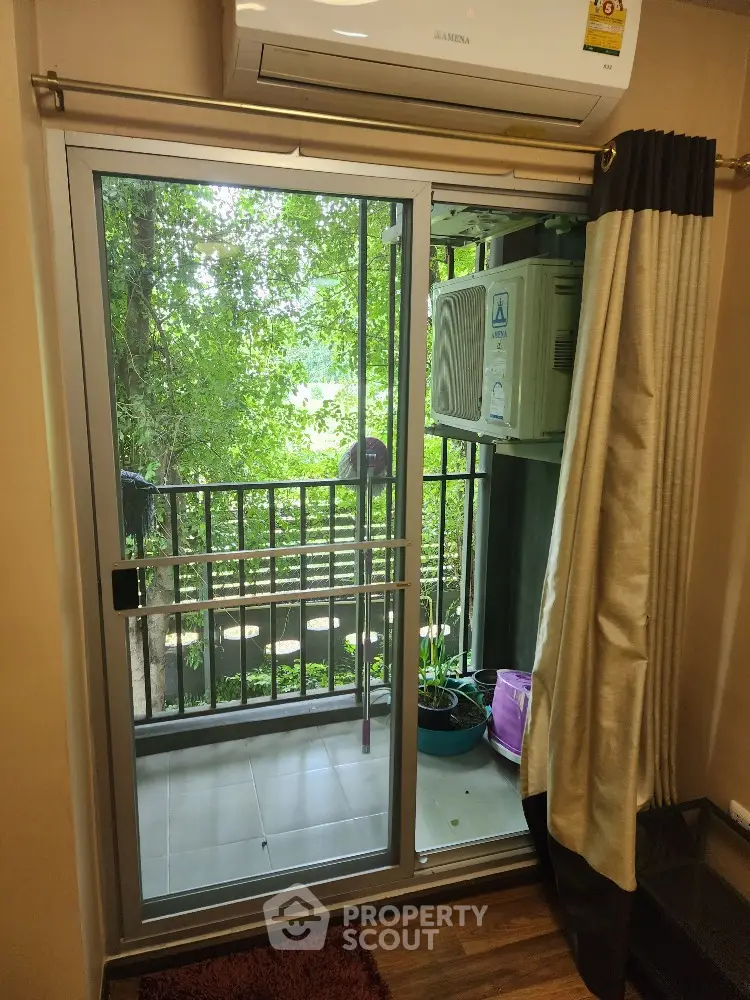 Cozy corner with a balcony view surrounded by lush greenery, perfect for a breath of fresh air and relaxation in a serene environment.
