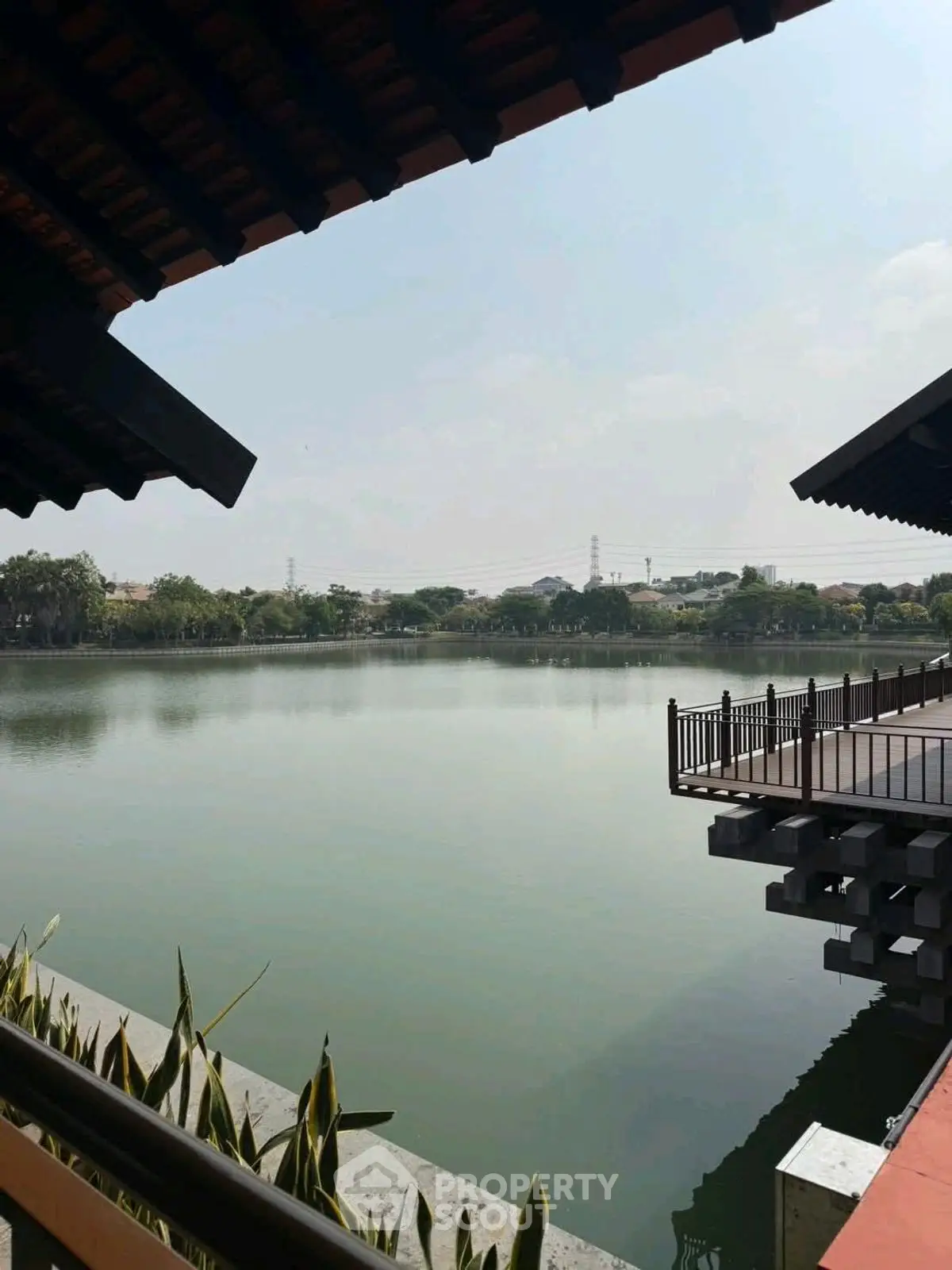 Serene lakeside view with modern architectural elements and lush greenery.