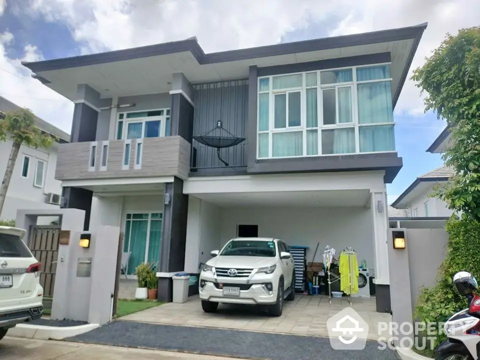 Modern two-story house with spacious driveway and contemporary design.