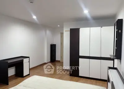 Spacious bedroom with modern furniture and ample storage space