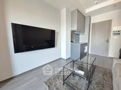 Modern living room with sleek TV and compact kitchen in stylish apartment