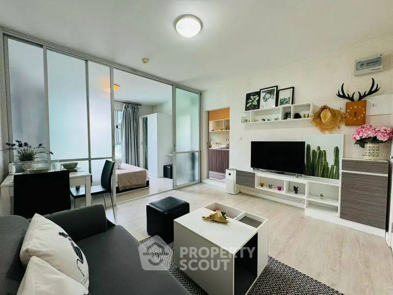 Modern living room with open layout and stylish decor, featuring a cozy seating area and sleek entertainment center.