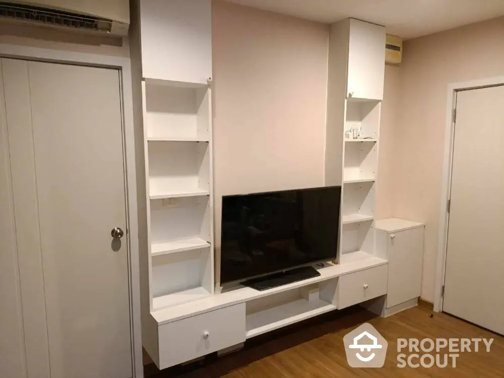 Modern living room with sleek white TV unit and wooden flooring