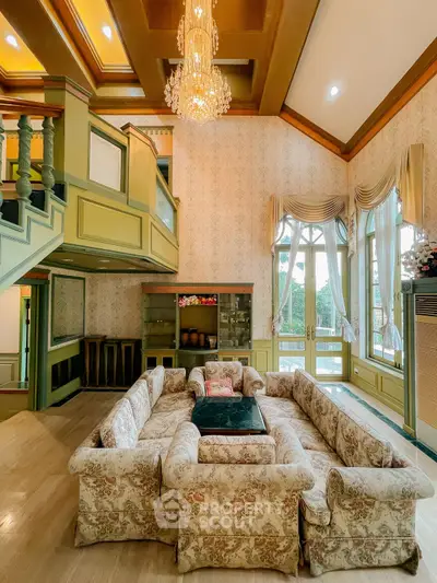 Luxurious living room with elegant chandelier and vintage decor, featuring a spacious seating area and large windows.