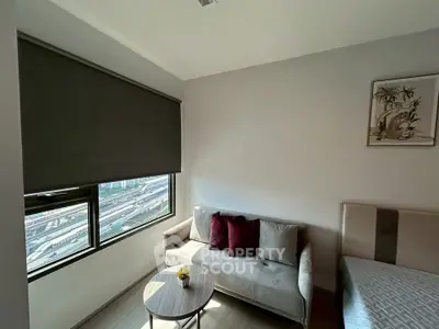 Modern living room with cozy sofa and city view window, perfect for urban living.