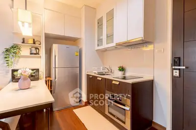 Modern kitchen with sleek cabinetry and built-in appliances in cozy apartment.