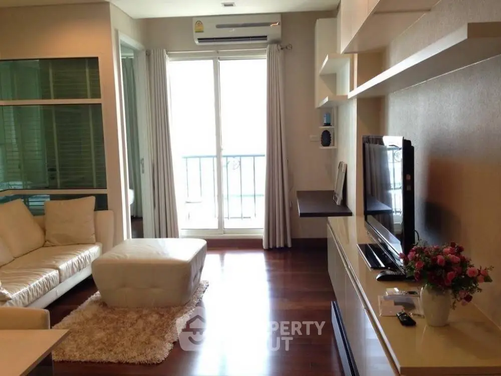 Modern living room with sleek furniture and balcony access, perfect for urban living.