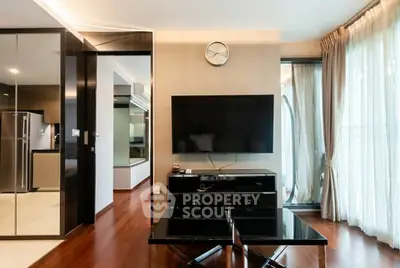 Modern living room with sleek design, large TV, and floor-to-ceiling windows for natural light.