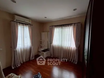 Spacious bedroom with elegant curtains and wooden flooring