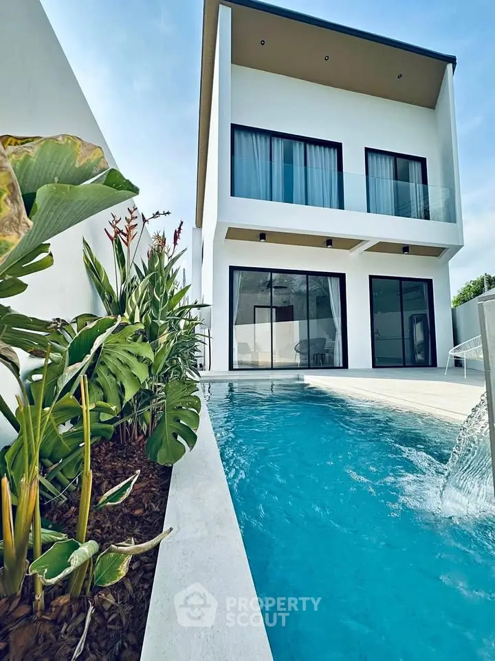 Modern two-story villa with private pool and lush garden, perfect for luxury living.