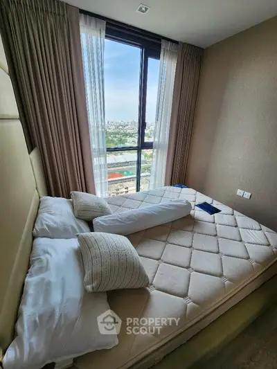 Cozy bedroom with large window offering stunning city view, featuring a comfortable bed and elegant decor.