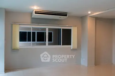 Spacious living room with modern air conditioning and large window for natural light.