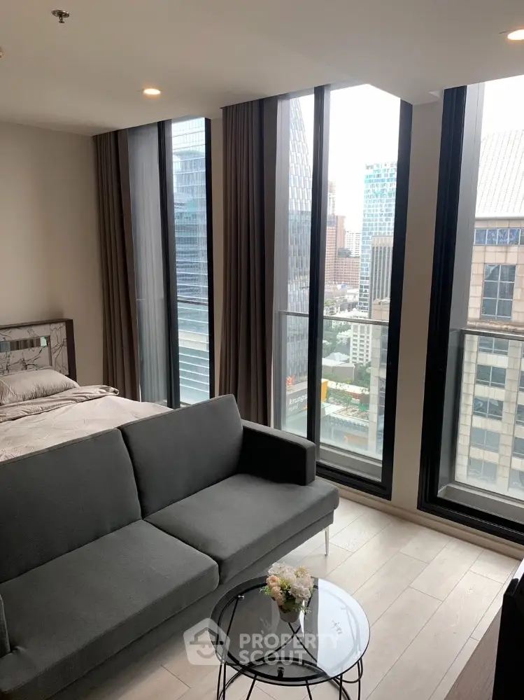 Modern living room with city view, floor-to-ceiling windows, and stylish furniture