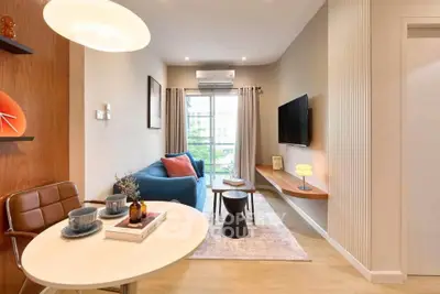 Modern living room with stylish decor, cozy seating, and natural light from large window.