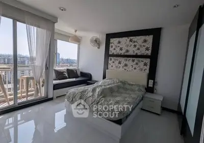 Modern bedroom with balcony and city view, featuring stylish decor and natural light.