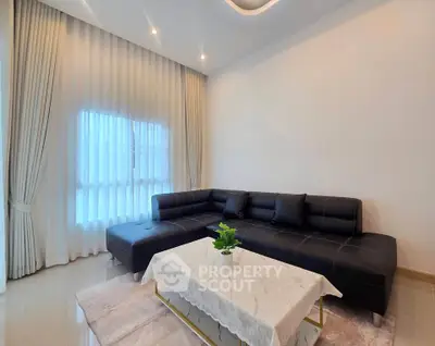 Elegant living room with modern black leather sofa and chic decor