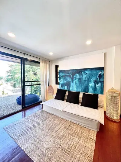 Bright living room with modern decor and large windows overlooking a scenic view.