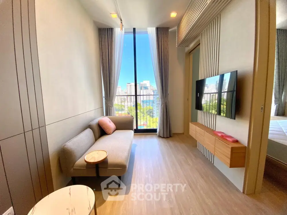 Modern living room with city view, sleek furniture, and large windows in a stylish apartment.