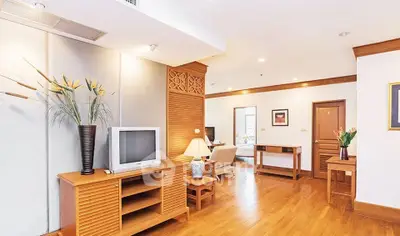 Spacious living room with wooden flooring and elegant decor in a modern apartment.