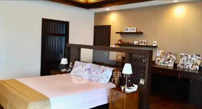 Spacious bedroom with elegant decor and cozy ambiance, featuring a stylish headboard and warm lighting.