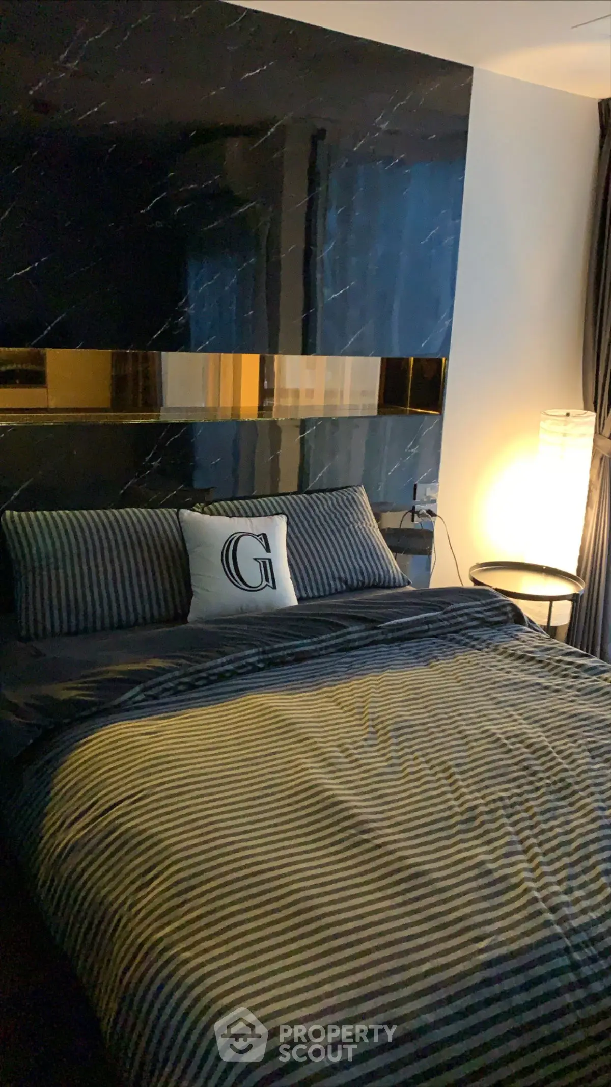 Luxurious bedroom with elegant striped bedding and ambient lighting