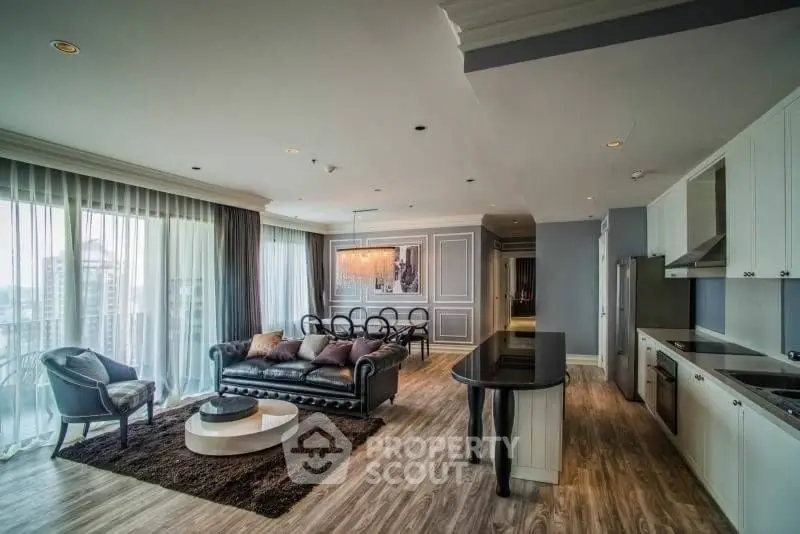 Luxurious open-plan living room with modern kitchen and elegant decor in high-rise apartment.