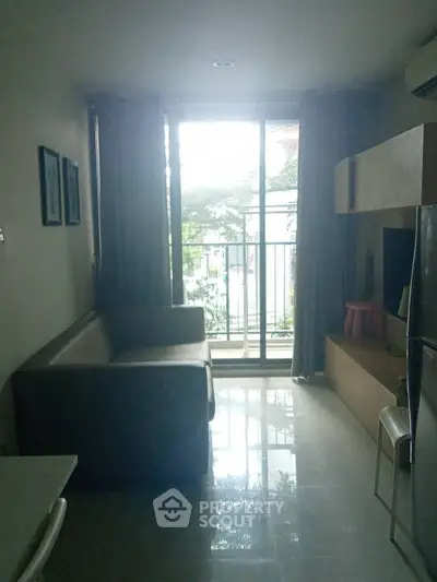 Cozy living room with natural light and balcony access in modern apartment.