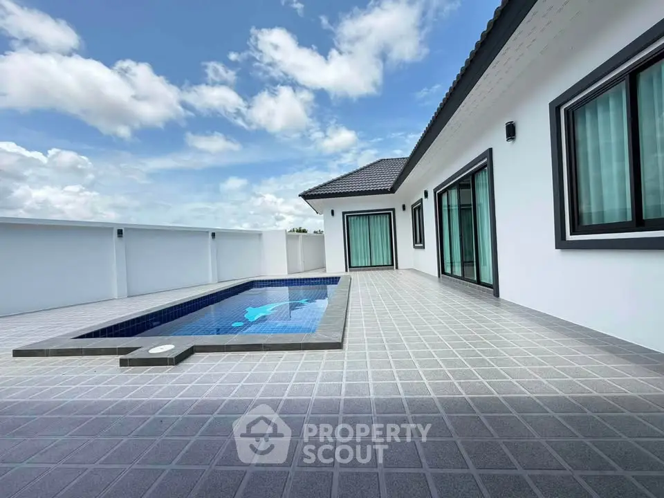Modern villa with private pool and spacious terrace under a clear blue sky.