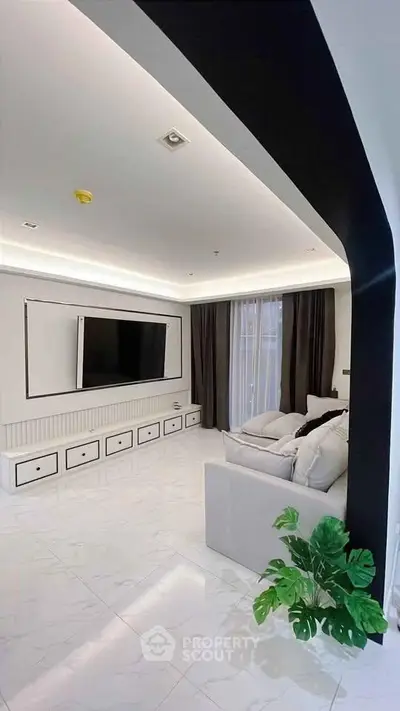Modern living room with sleek design, large TV, and elegant lighting, perfect for contemporary living.