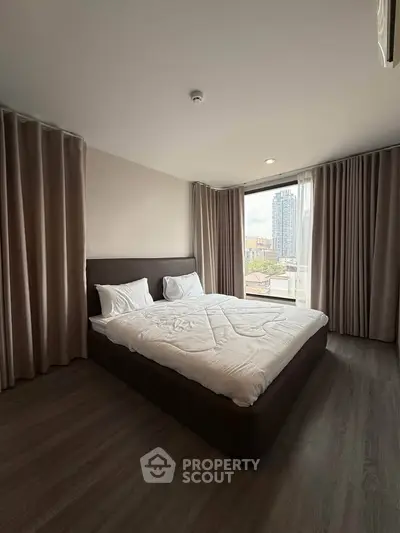 Spacious bedroom with city view, featuring a large bed and modern decor, perfect for urban living.