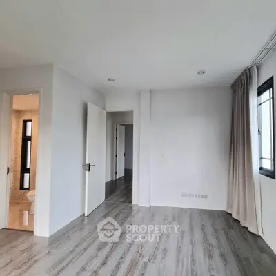 Spacious modern bedroom with elegant flooring and natural light