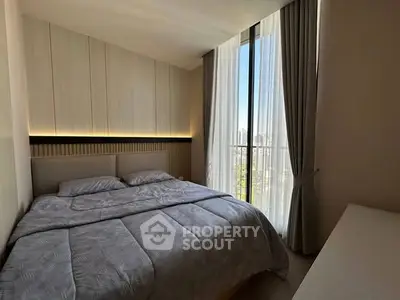 Modern bedroom with large window and stylish decor in urban apartment