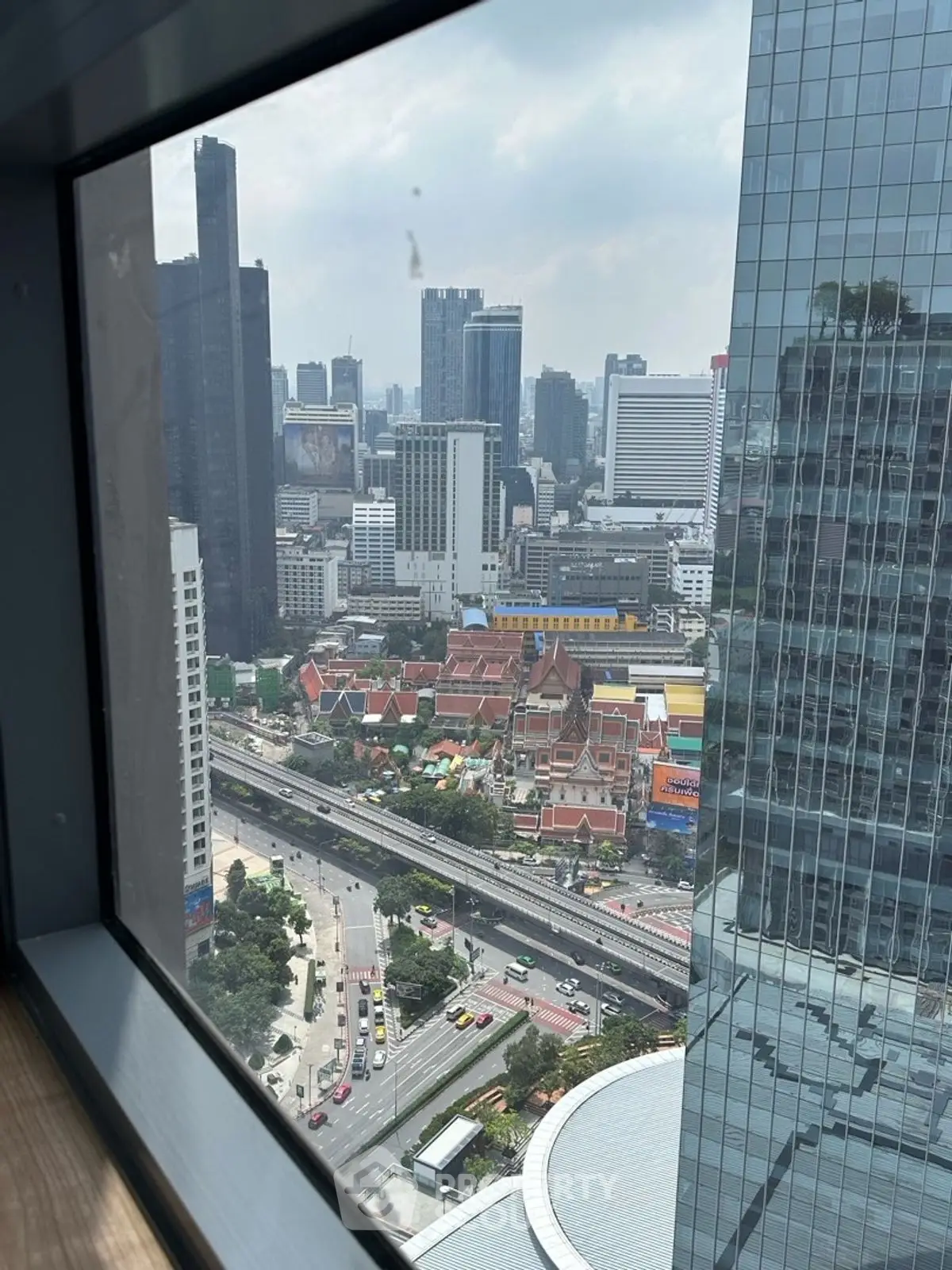 Stunning cityscape view from high-rise building window, showcasing urban skyline and vibrant city life.